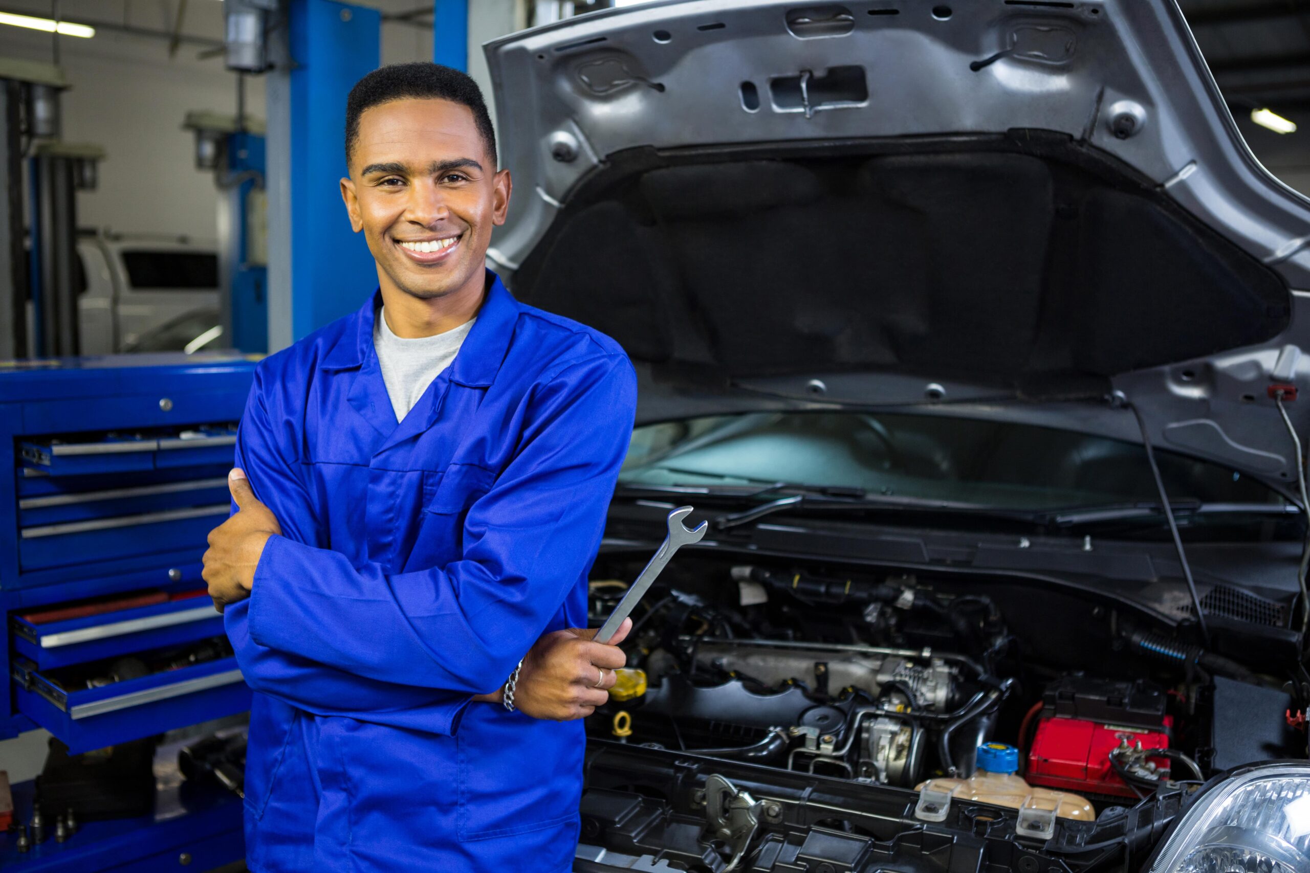 smiling-mechanic-with-arms-crossed-spanner-min-scaled.jpg